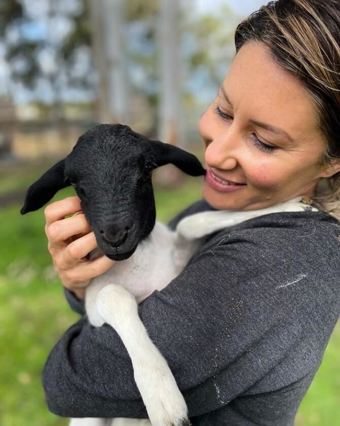 Lady Holding A Lamb At 11 Acre Farm